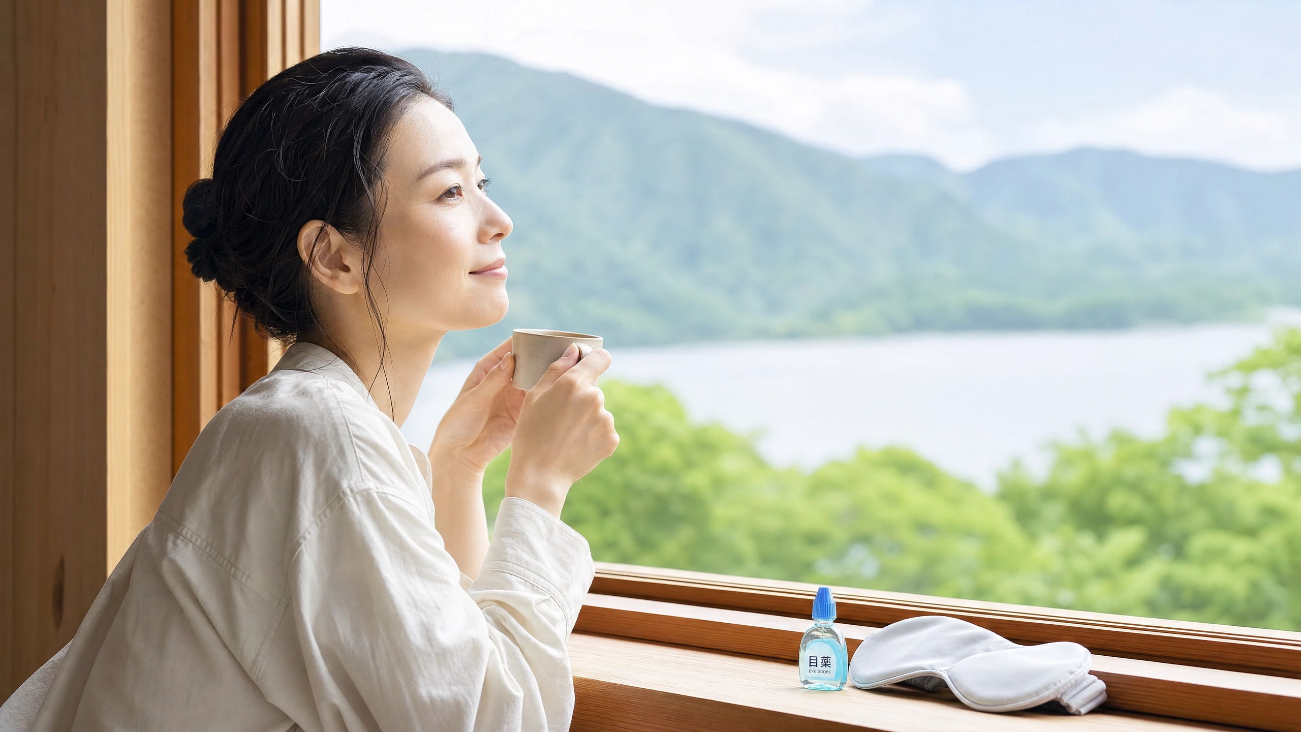 窓から景色を見てリラックスする30代女性