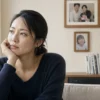 家族写真を見つめる30代独身女性