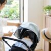 夏のベビーカー外出前に親が日よけと持ち物を整える明るい室内イメージ
