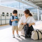夏休みの新幹線移動前に親子で荷物とベビーカーを整えるイメージ