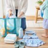 子連れプールの外出前に親が水着やタオルやボトルやプールバッグを玄関近くで準備する夏の朝のイメージ