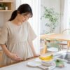 夏の台所で子どもの昼ごはん準備を前にひと息つく妊娠初期の母親のイメージ