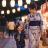 夏祭りの灯りの中を親子で歩く子連れ外出のイメージ