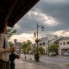 夏の街で夕立前の空を見上げる人と暗い雲の実用的なイメージ