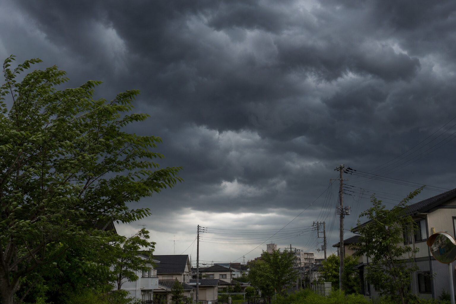 夏の午後に黒い雲が近づき風が変わる空のイメージ