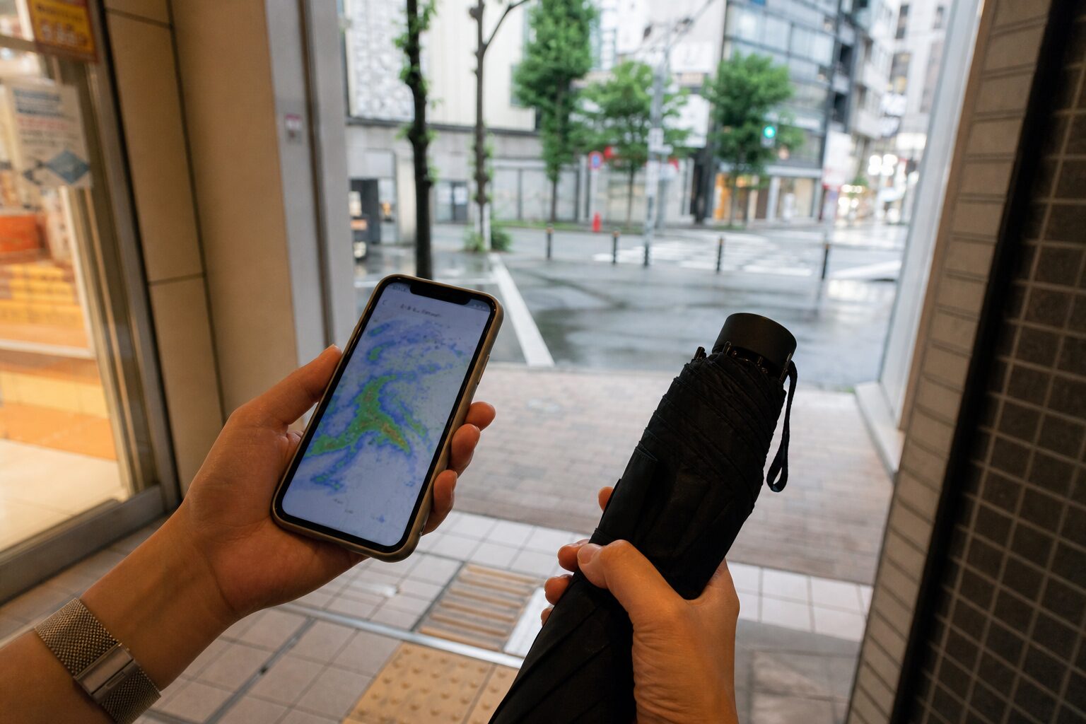 外出前にスマートフォンで雨雲を確認しているイメージ
