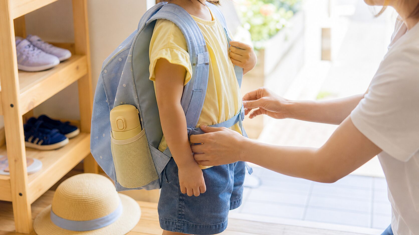 子どもが水筒を安全に持てるようリュックを整えるイメージ