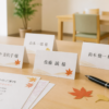 敬老会の席札と黒ペンを明るい室内テーブルに並べた準備イメージ