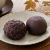 お彼岸前の和菓子売り場でおはぎとぼたもちを見比べるやわらかな秋のイメージ