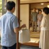 お盆の帰省先で紙袋入りの手土産を持って挨拶する家族のイメージ