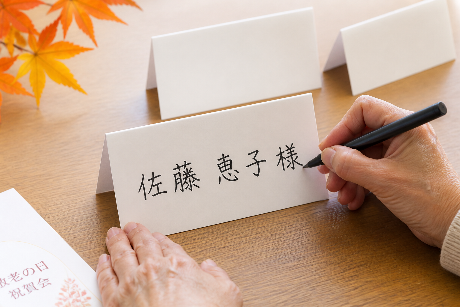 敬老会の席札に大きめの文字で名前を書く手元イメージ