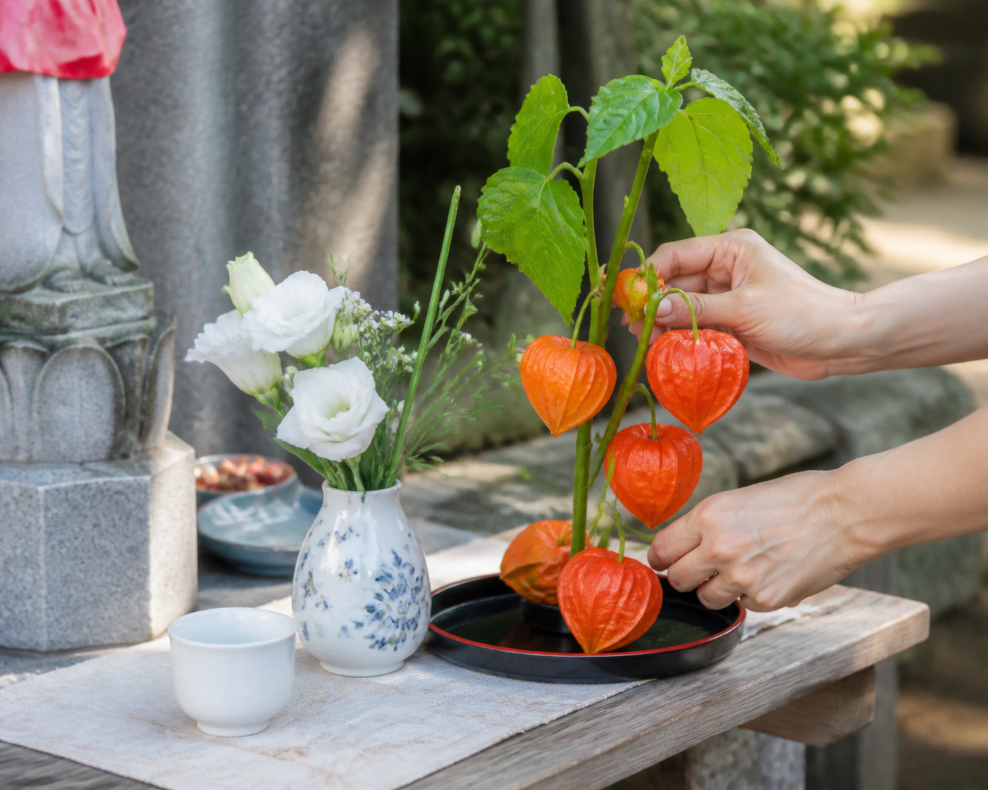 ほおずきを花と並べて地蔵盆のお供えを整える手元イメージ
