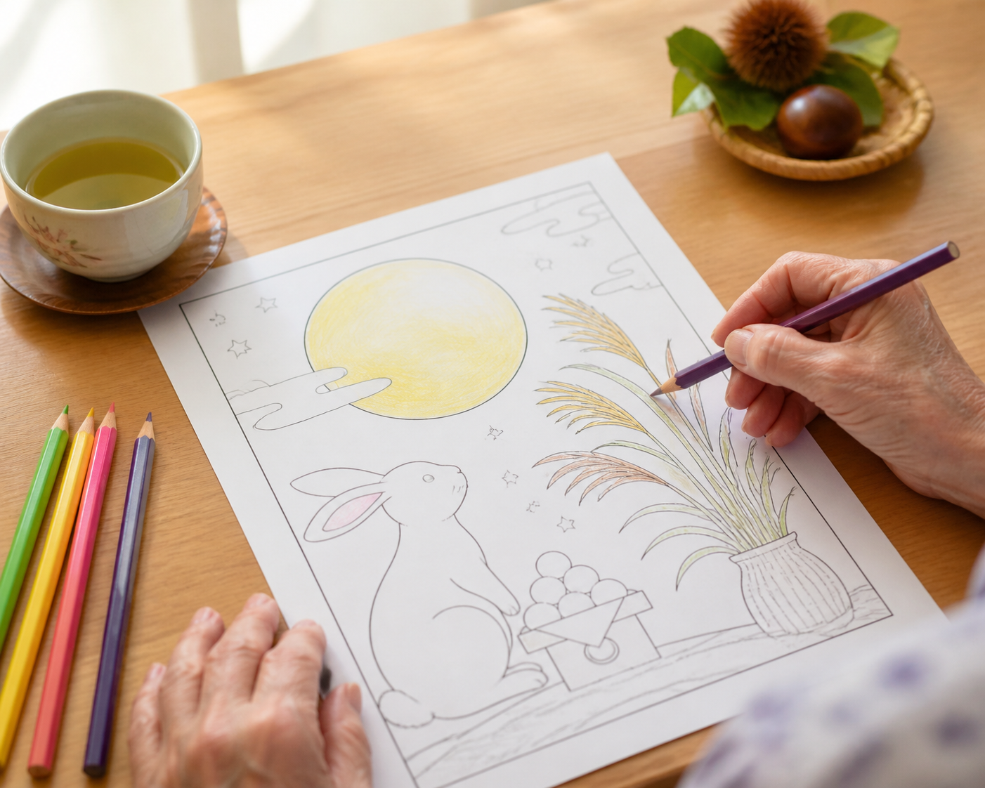 月見とうさぎの塗り絵見本を机に広げる9月レク準備イメージ