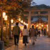 秋祭りの提灯が並ぶ夕方の境内へ歩く人々の後ろ姿