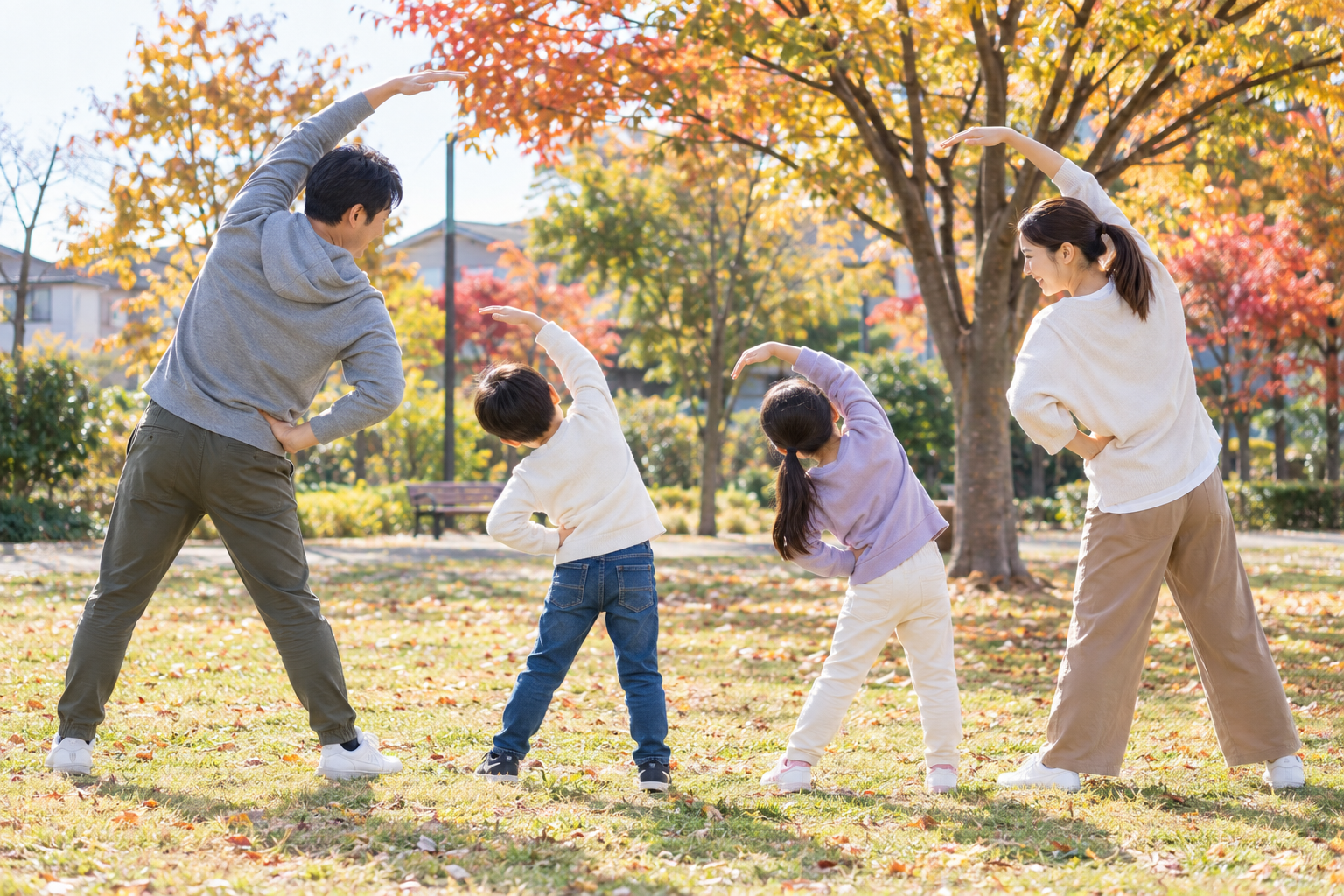 秋の公園で軽くストレッチをする家族