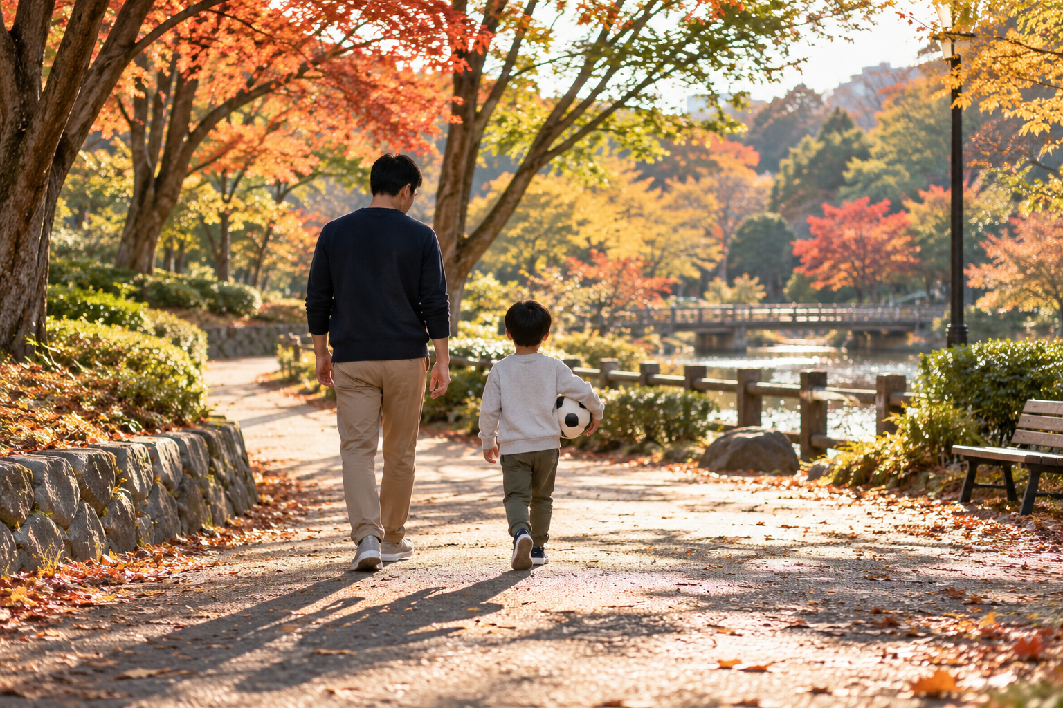紅葉の公園をボールを持って歩く親子
